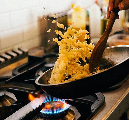 Persona cocinando con una sartén